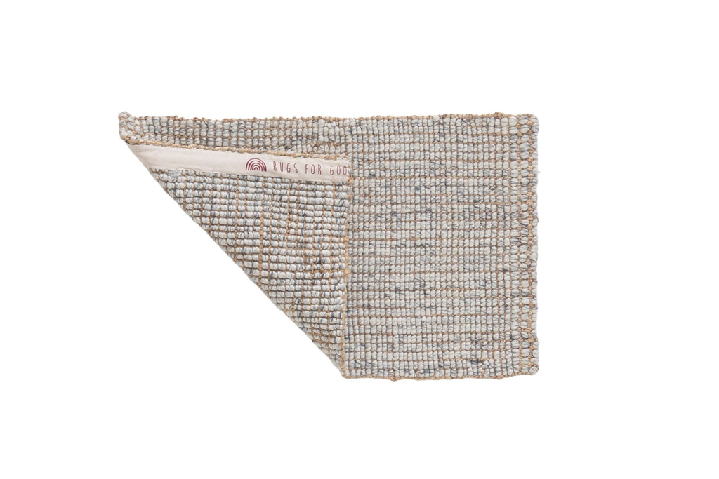 Textured wool and jute doormat with a subtle pattern on a white background